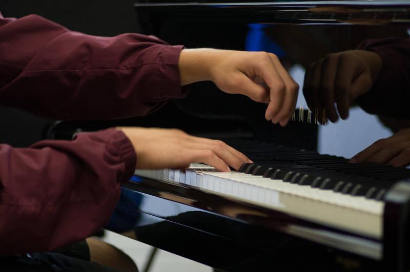 A young student plays the piano.