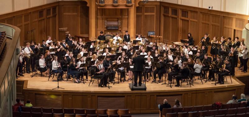 The Lawrence Community Symphonic Band and Wind Ensemble perform together onstage during a concert.