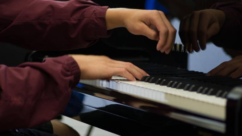 A young student plays the piano.