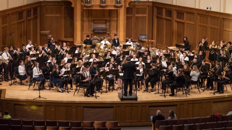 The Lawrence Community Symphonic Band and Wind Ensemble perform together onstage during a concert.
