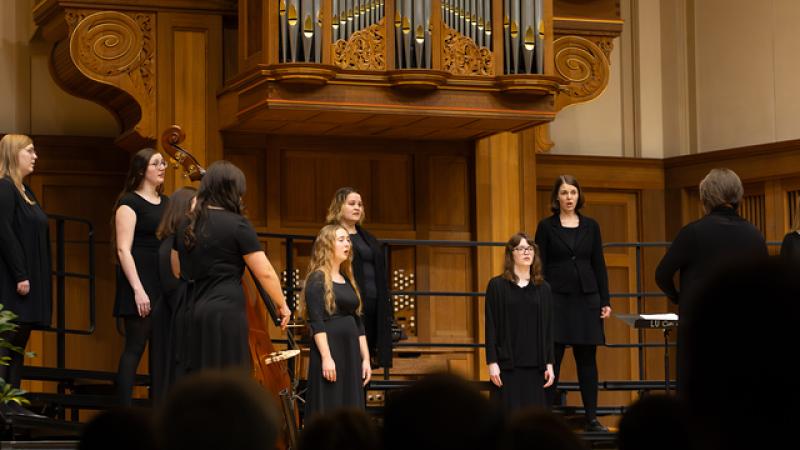 Women in all black singing in chapel