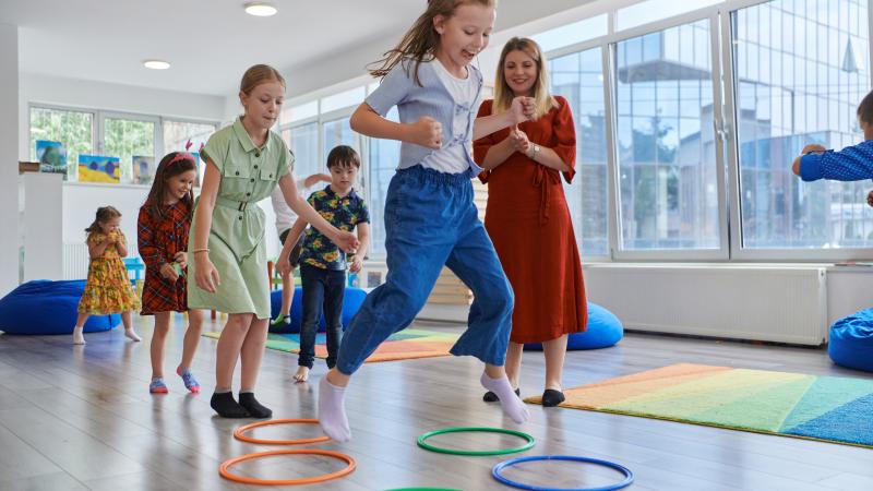 children jumping through hula hoops