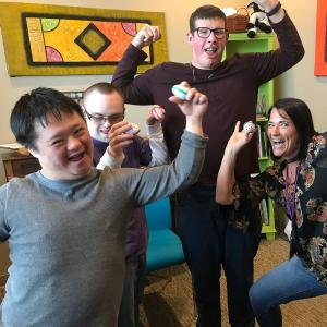 Three students and a teacher pose with shakers during a Music for People with Disabilities class.